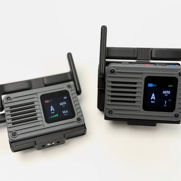 白い台の上に並べた映像伝送機「DJI SDR Transmission 2」の送信機と受信機。本体の小さな画面に接続状態が表示されている